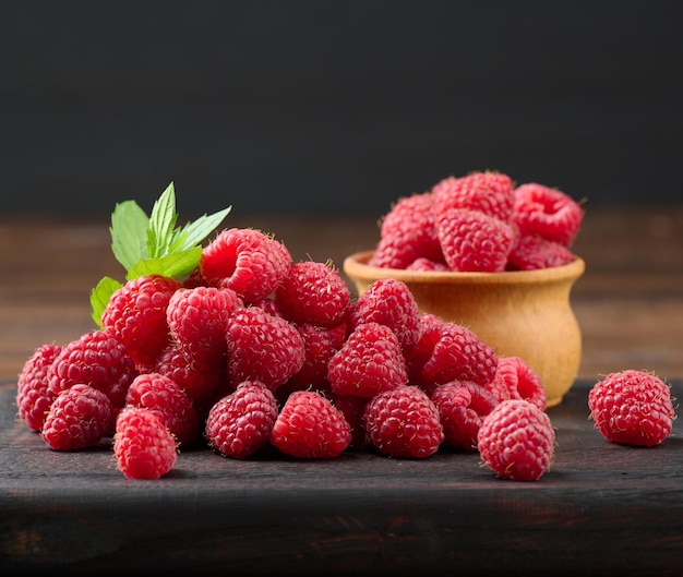 Ripe red raspberries on a brown wooden board