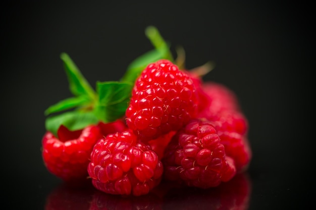 Ripe red raspberries closeup isolated on black background