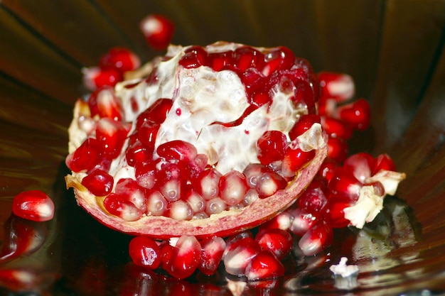 Ripe and red seeds of pomegranate on the dark