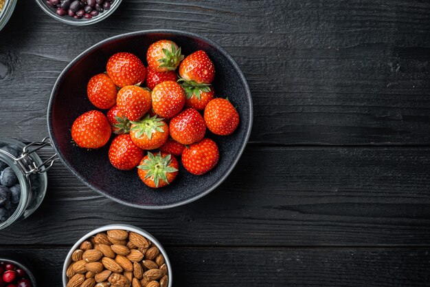 Ripe red strawberries in a black bowl