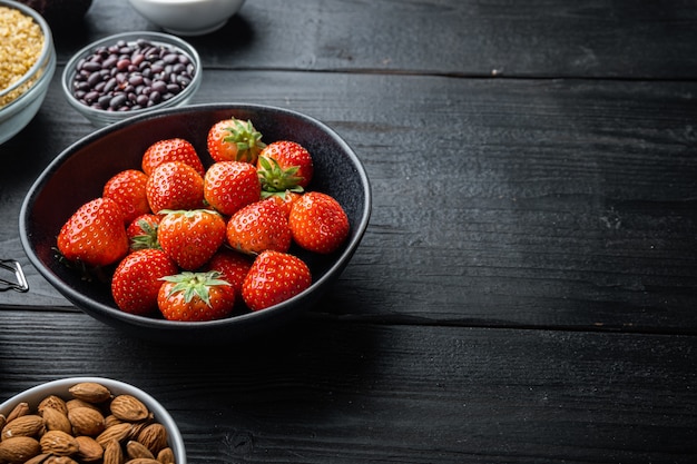 Ripe red strawberries in a black bowl