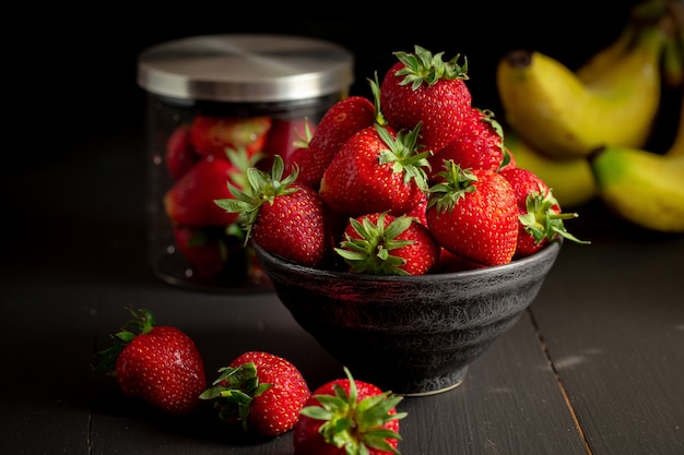 Ripe red strawberries on black wooden table