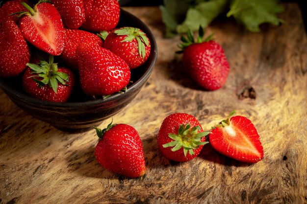 Ripe red strawberries on black wooden table