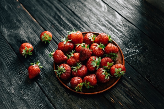 Ripe red strawberries on a wooden plate