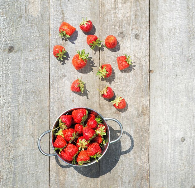 Ripe red strawberries on wooden table top view copy space