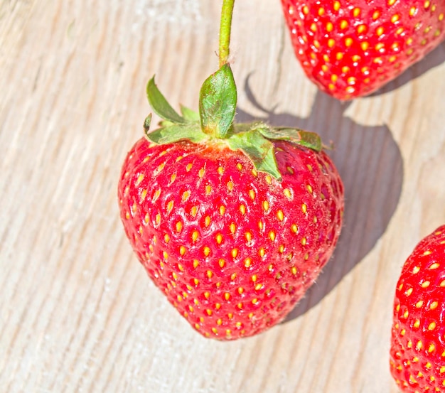 Ripe red strawberries on wooden table