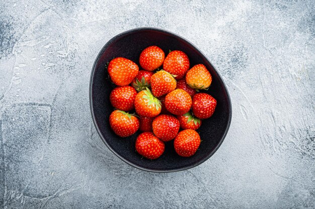 Ripe red strawberry, top view, on textured background.