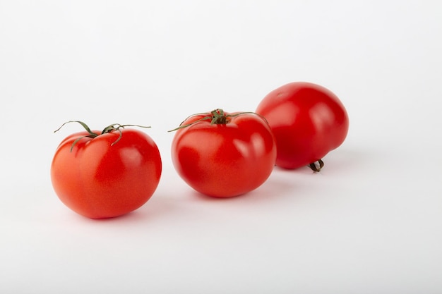 Ripe red tomatoes on a white background