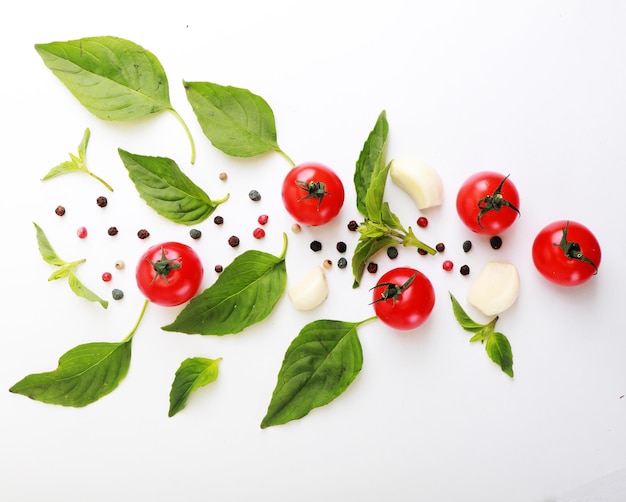 Ripe red tomatoes with basil pepper and garlic isolated on white background Top view