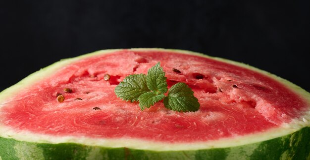 Ripe red watermelon. Black background, close up