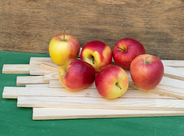 Ripe red and yellow apples on wooden background