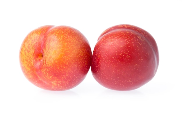 спелые плоды рубиновой сливы на белом фоне