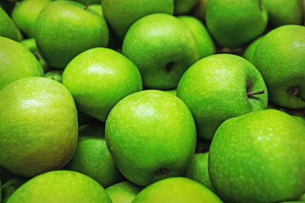 Ripe selected granny smith apples in rows at a grocery shop for sale. Green background of granny smith apples. Horizontal. Top view.