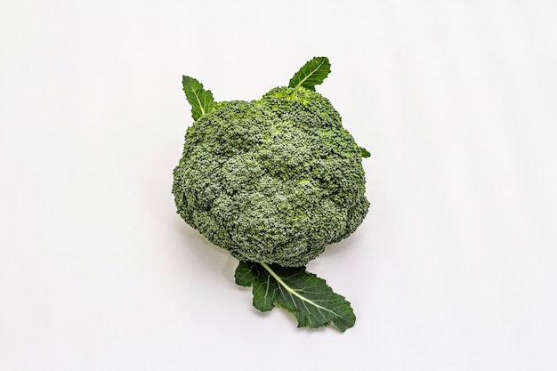 Ripe single broccoli. Fresh whole head of cabbage, green leaves.