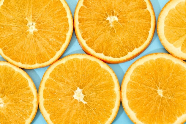 Ripe slice orange fruit on blue background. top view