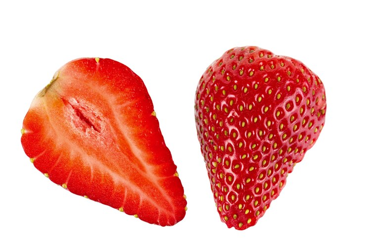 白い背景の上の熟したスライスしたイチゴの果実。孤立