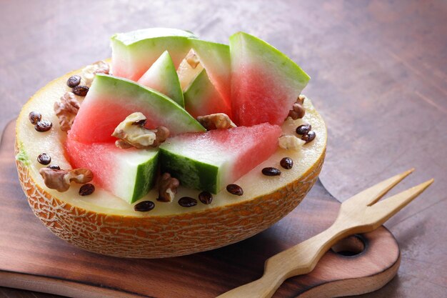 Ripe slices of watermelon and melon on a wooden board on a dark background Healthy and beautiful watermelon and melon closeup