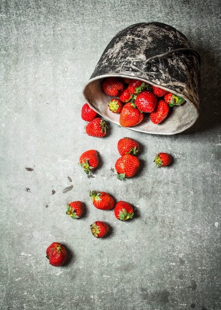 Photo ripe strawberries in an old pot.