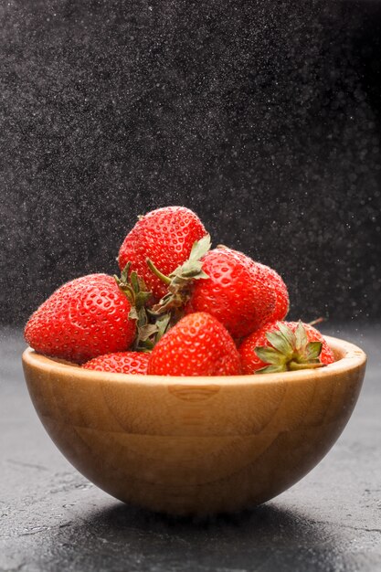 Ripe strawberries in wooden bowl