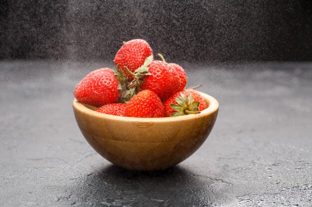 Ripe strawberries in wooden bowl