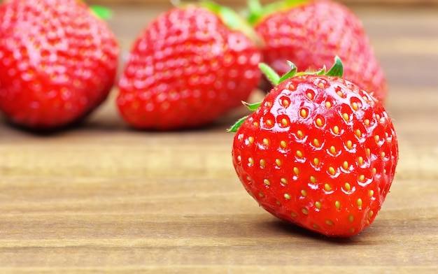 Ripe strawberries on wooden table. Fresh strawberries on wooden background