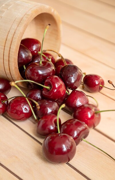 Ripe sweet cherries scattered on wooden table surface