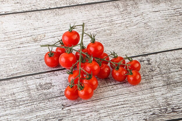Ripe sweet Cherry tomato branch over background