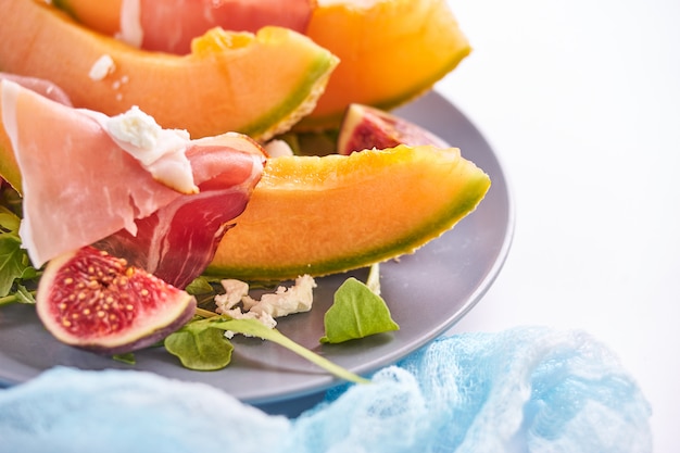 Ripe sweet melon with ham and arugula