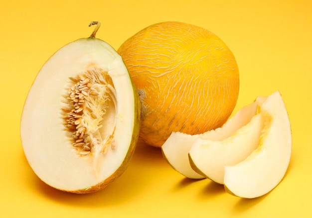 Ripe sweet melons on yellow background