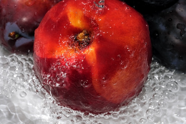 Ripe sweet nectarine is washed under a stream of clean water close-up macro photography