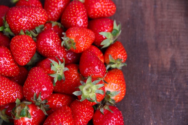 Ripe sweet strawberries on color wooden background