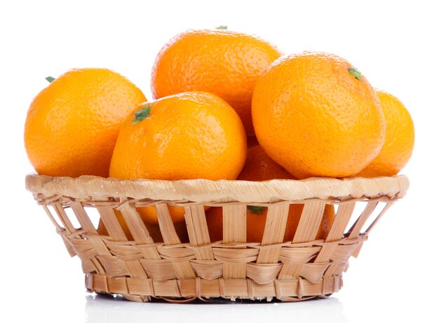 Ripe sweet tangerines in wicker basket, isolated on white