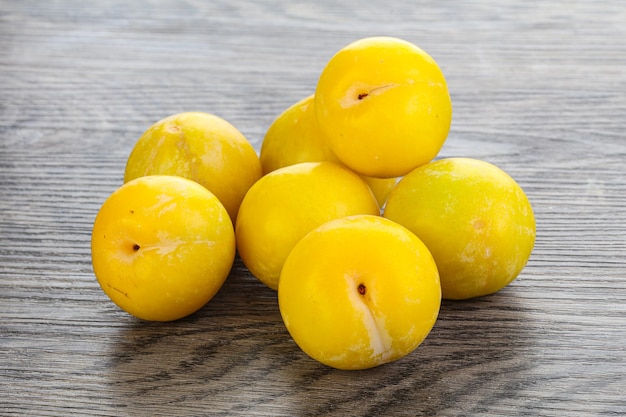 Ripe sweet yellow plum heap over background