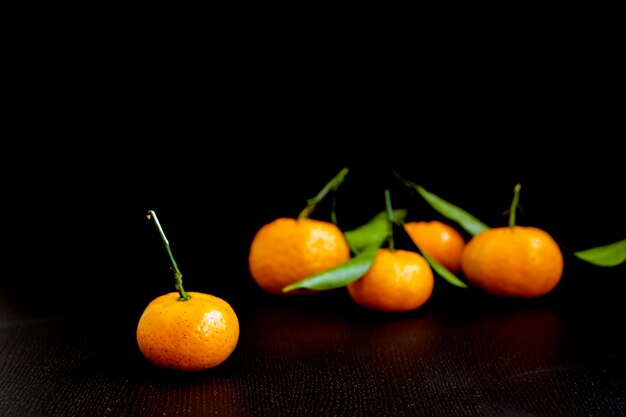 Ripe tangerines on a black background.