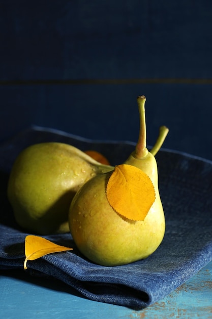 Photo ripe tasty pears on wooden table on dark background