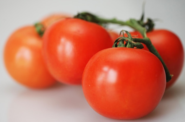 Ripe tomato branch over white close up