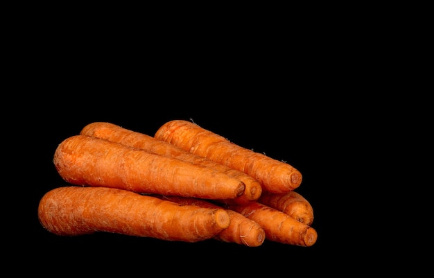 Ripe vegetable root vegetable carrot on black background