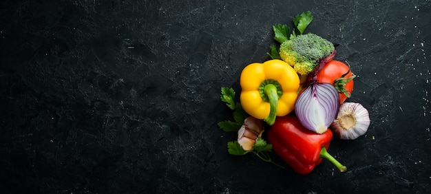 Ripe vegetables Fresh vegetables on black stone background Tropical fruits Top view Free space for your text