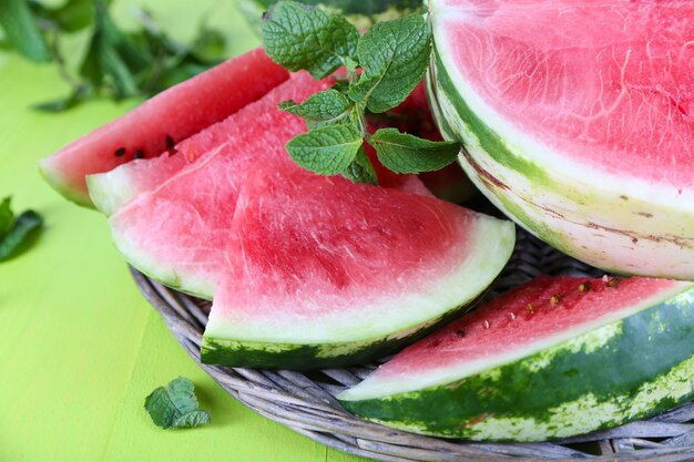 Ripe watermelons on wicker tray on wooden table