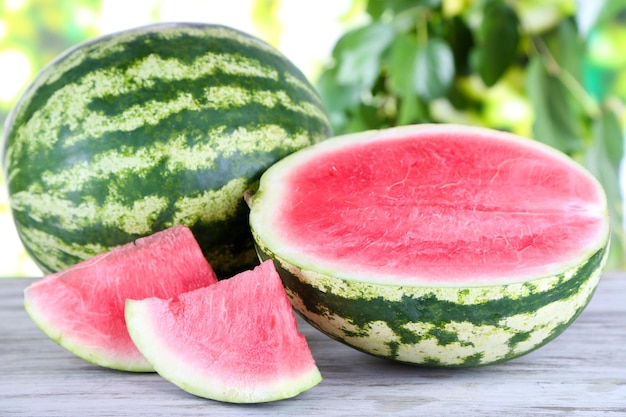 Ripe watermelons on wooden table on nature background