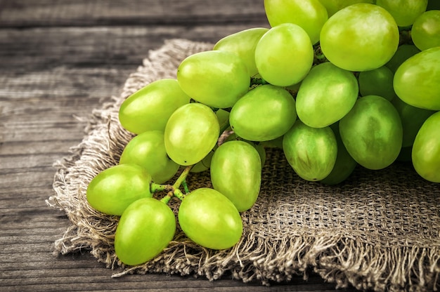 Ripe white grape bunch on burlap napkin