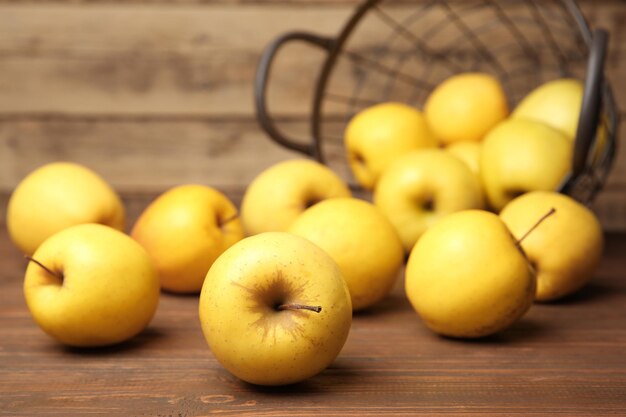 Ripe yellow apples on wooden table