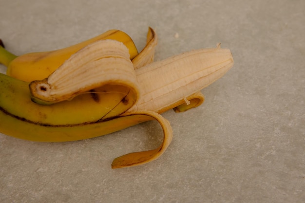 Foto banana gialla matura banana sbucciata sul tavolo della cucina
