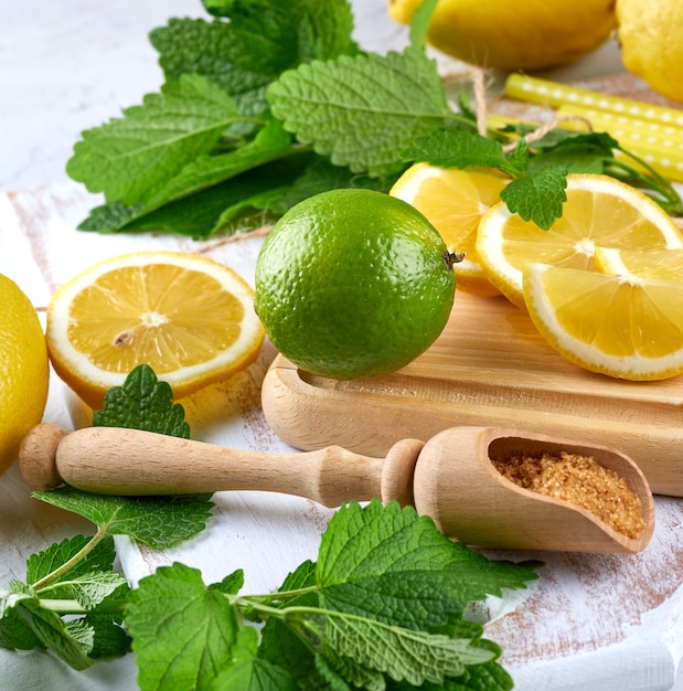 Ripe yellow lemons and lime, brown sugar and a bunch of fresh mint 