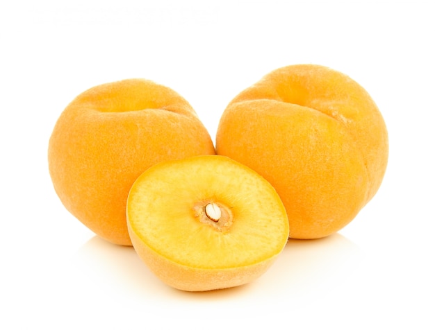 Ripe yellow peach on white wall