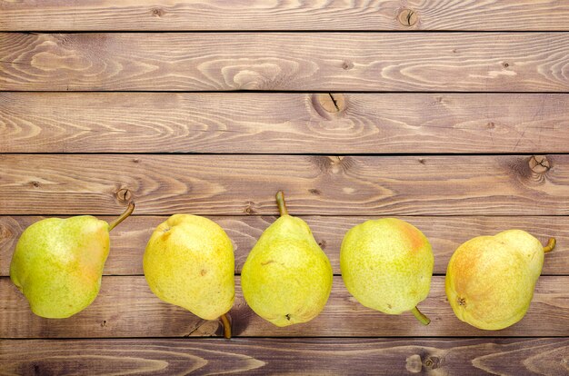 Ripe yellow pears on wooden rustic background. Summer fruits, harvest.