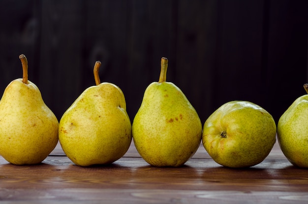 Photo ripe yellow pears on wooden rustic background. summer fruits, harvest.