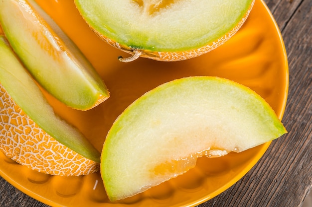 Ripe yellow sliced melon on plate