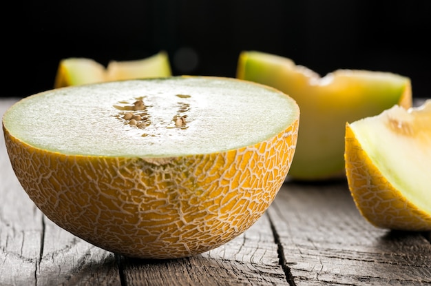 Ripe yellow sliced melon on wooden table