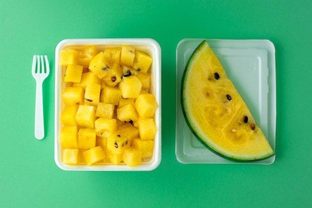 Ripe yellow watermelon cut into pieces in a plastic white bowl